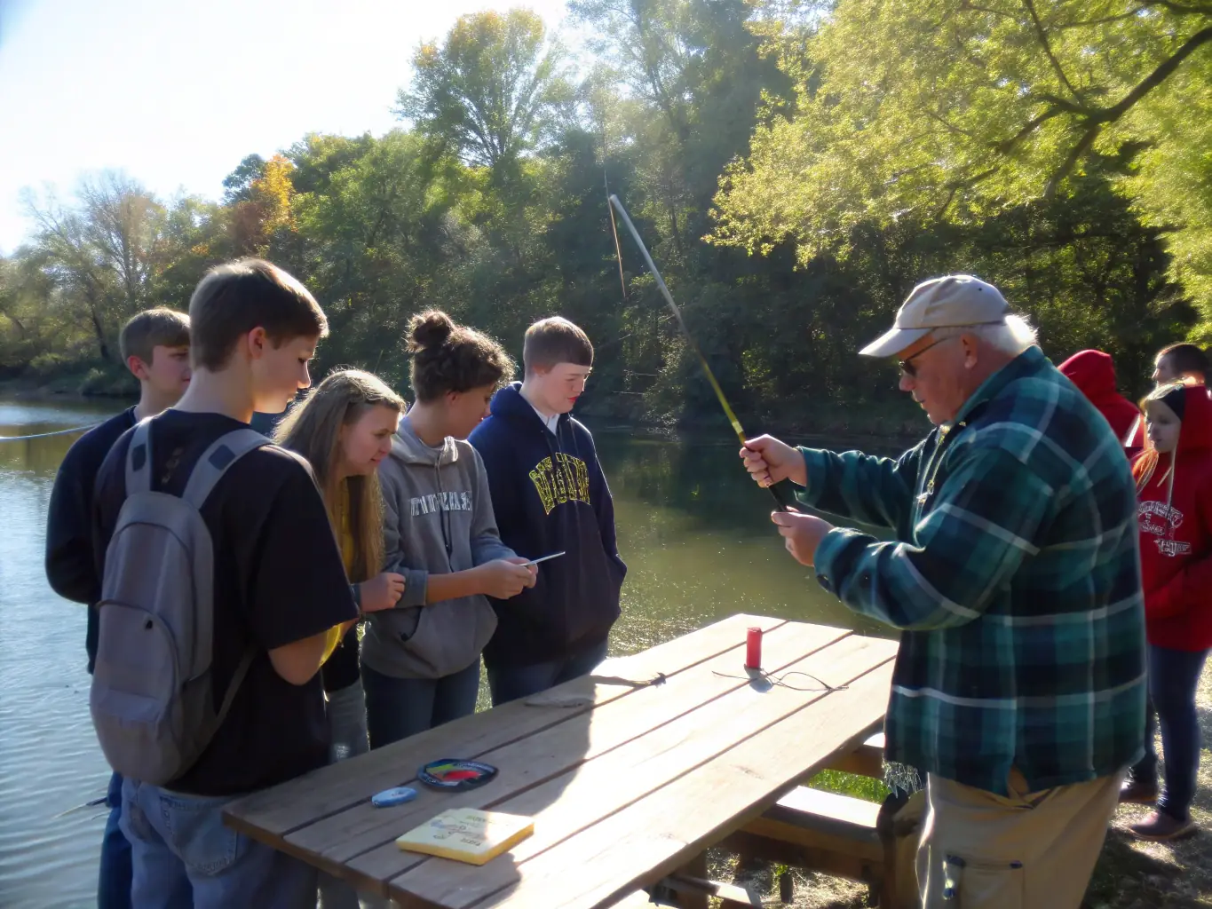 A group of people participating in a guided fishing tour on the Touvre river, learning about local fish species and sustainable fishing techniques.